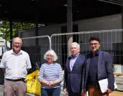 Trois et une femme posent devant un chantier 