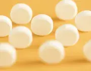 des pilules blanches sur fond jaune