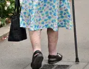 Une femme âgée marche dans la rue.