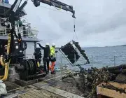 Des hommes récupèrent des déchets sous-marins sur un bateau de pêchee