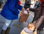 Deux personnes échangent un seau de déchets.