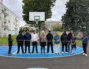 Des personnes coupant un ruban devant un terrain de basket.