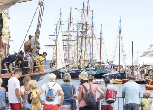Des visiteurs des Fêtes maritimes de 2026 le long des quais, face aux bateaux 