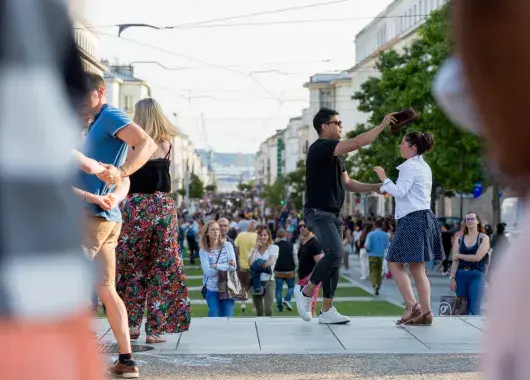 Un couple danse entouré de monde.