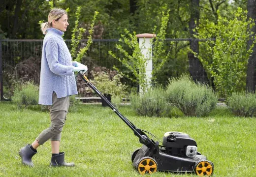 Une femme tondant la pelouse