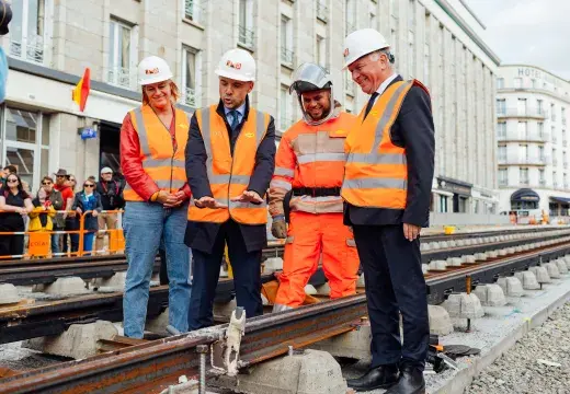 Des gommes et une femme regardent la première soudure de rails sur la ligne B du tramway de Brest.  