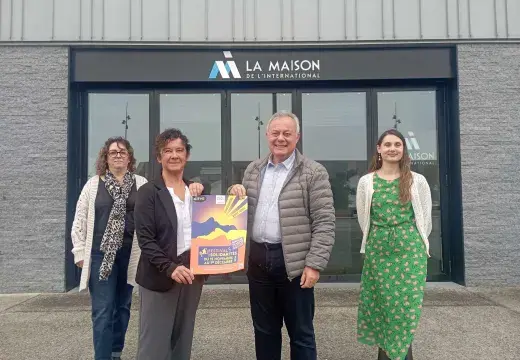 Quatre personnes posent devant un bâtiment.