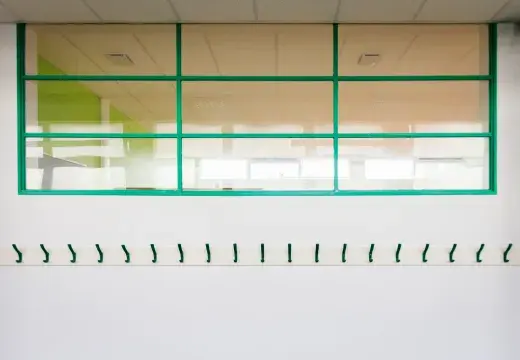 Des porte-manteaux vides dans un couloir.