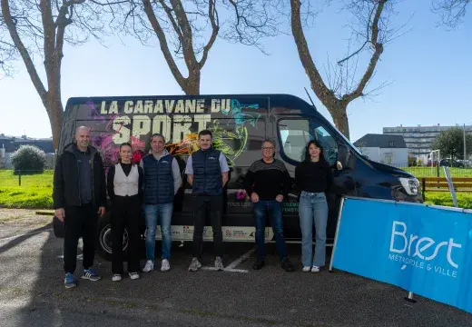 Plusieurs personnes devant un stade de foot.