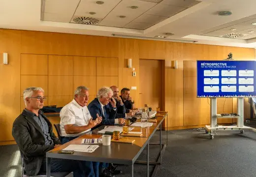 Plusieurs personnes assises à un bureau.
