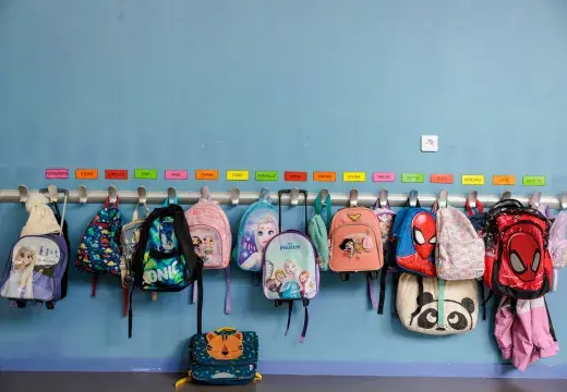 Des cartables d'écoliers accrochés au porte-manteaux. 