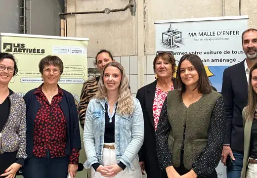 Des homes et des femmes posent devant des panneaux