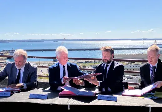 Des hommes signent un document officiel sur le parvis de la gare de Brest, au-dessus du port
