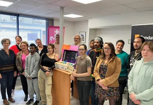 Des femmes et des hommes posent devant une borne d'arcade