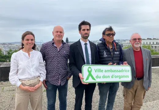 Des hommes et des femmes portant la plaque Ville ambassadrice du don d'organes 