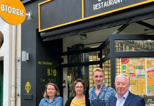 deux hommes et deux femmes posent devant un restaurant