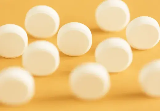 des pilules blanches sur fond jaune