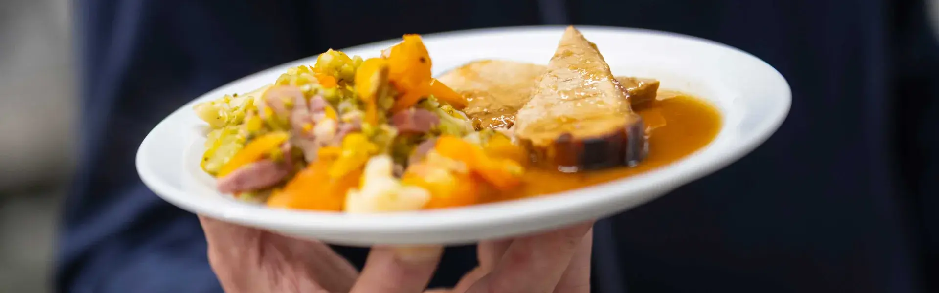 Un homme présentant une assiette pleine