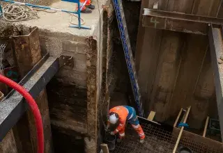 Deux ouvriers en train de travailler dans un trou.