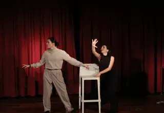Photo montrant deux comédiennes jouant une scène de théâtre.