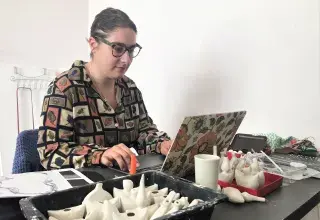 Une jeune femme travaille face à son ordinateur