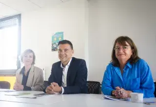 Trois personnes assises à une table.