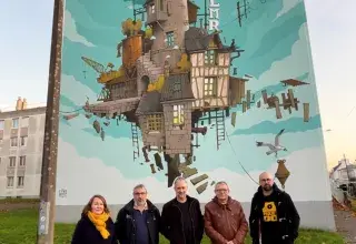 Cinq personnes devant le mur peint d'un immeuble.