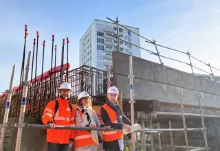 deux hommes et une femme en tenue de chantier au pied du futur pont de Kergoat