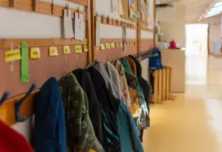 couloir d'une école avec des manteaux d'enfants accrochés au mur