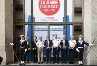 Plusieurs personnes coupent un ruban devant une grande porte.