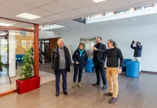 Plusieurs personnes parlent dans un hall. 