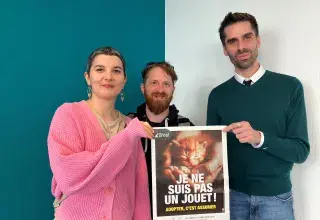 Une femme et deux hommes présentent une affiche