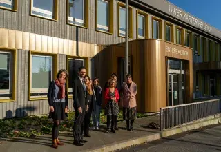 Plusieurs personnes devant un bâtiment.
