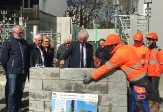Des hommes posent la première pierre du futur local associatif de Quéliverzan 