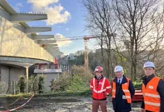 Trois hommes posent devant la pose du tablier du nouveau pont Schuman