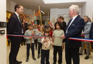 Deux adultes entourent des enfants.
