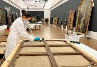 Une femme nettoie le revers d'un tableau au musée des Beaux-arts de Brest