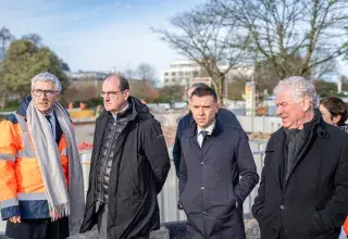 Plusieurs personnes discutent sur un chantier. 