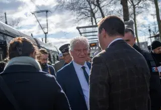 Plusieurs personnes devant un tramway.