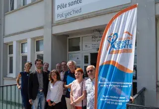 Plusieurs personnes posent devant un bâtiment.