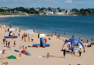des personnes sur la plage du moulin blanc et dans l'eau