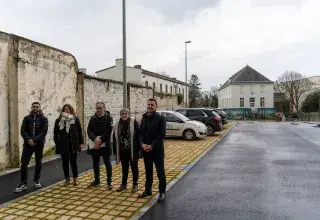 Plusieurs personnes posent sur un parking. 