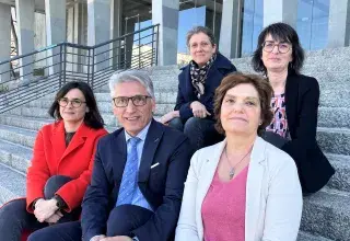Un homme et des femmes assis sur les marches de l'hôtel de ville 
