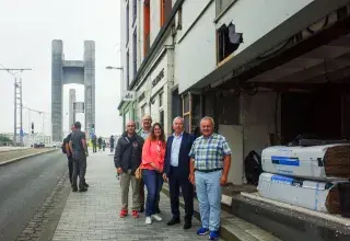 Des personnes devant un bâtiment en travaux.
