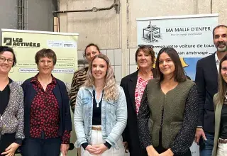 Des homes et des femmes posent devant des panneaux