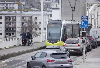 Vue du pont de Recouvrance traversé par un tramway, des voitures et des vélos 