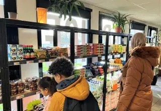 Une mère de famille et ses enfants découvrent les rayons de l'épicerie solidaire de Pontanézen
