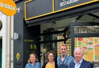deux hommes et deux femmes posent devant un restaurant