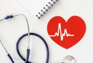 Un stéthoscope, avec un coeur dessiné et un carnet de notes 
