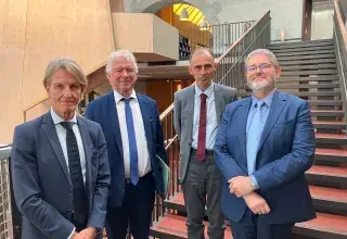 Quatre hommes posent sur un escalier 